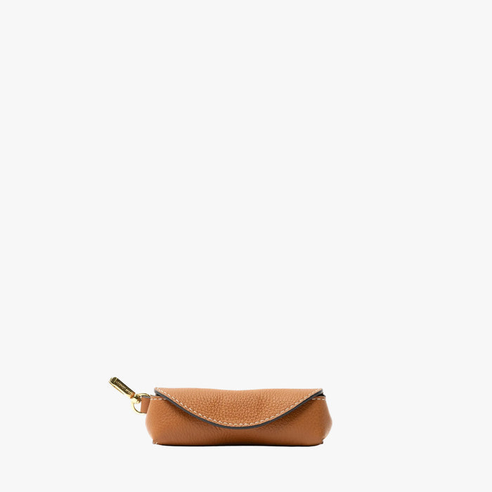 STOW London's Lipstick Case in Earth Tan pebbled leather featuring a gold-coated stainless steel clip on a light grey background
