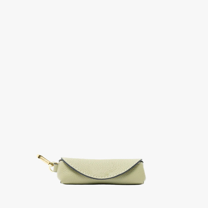 STOW London's Lipstick Case in Pale Green pebbled leather featuring a gold-coated stainless steel clip on a light grey background