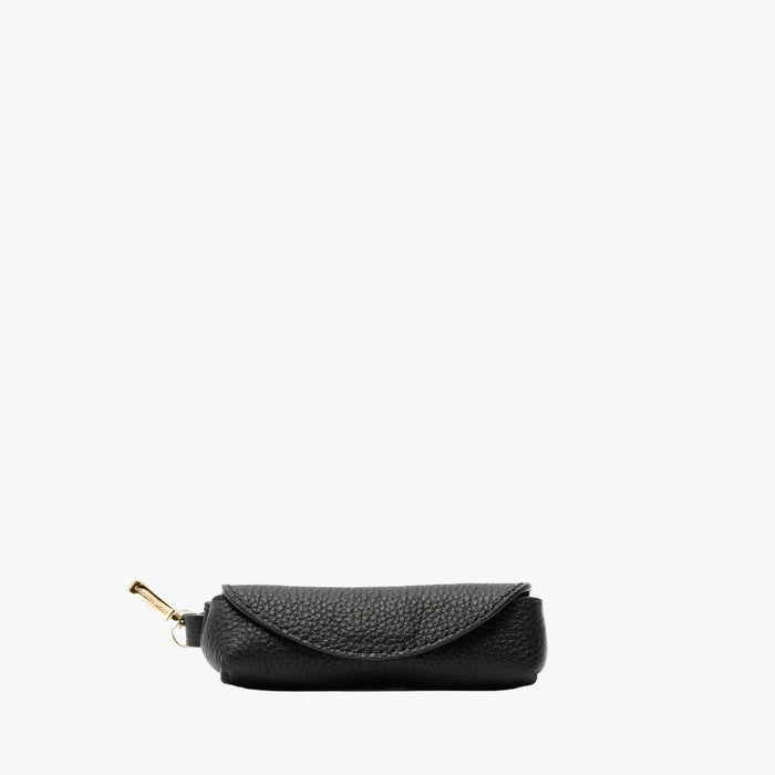 STOW London's Lipstick Case in Black pebbled leather featuring a gold-coated stainless steel clip on a light grey background