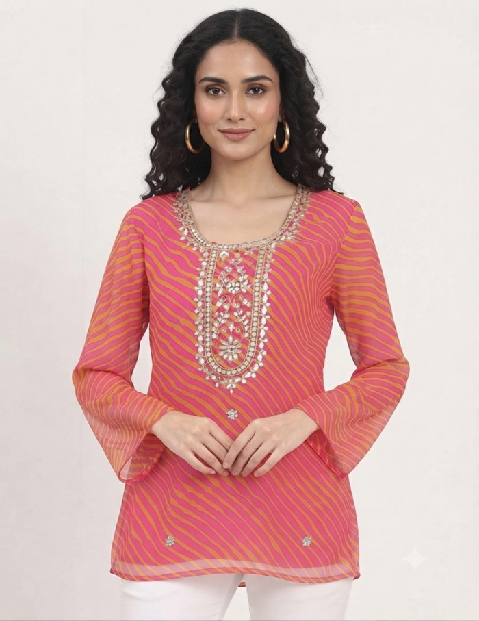 Model wearing a vibrant pink and orange leheriya tunic with detailed embroidery against a neutral background