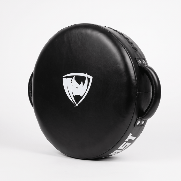 PROLAST round punch shield in black, standing on edge with the white rhino shield logo on the striking face